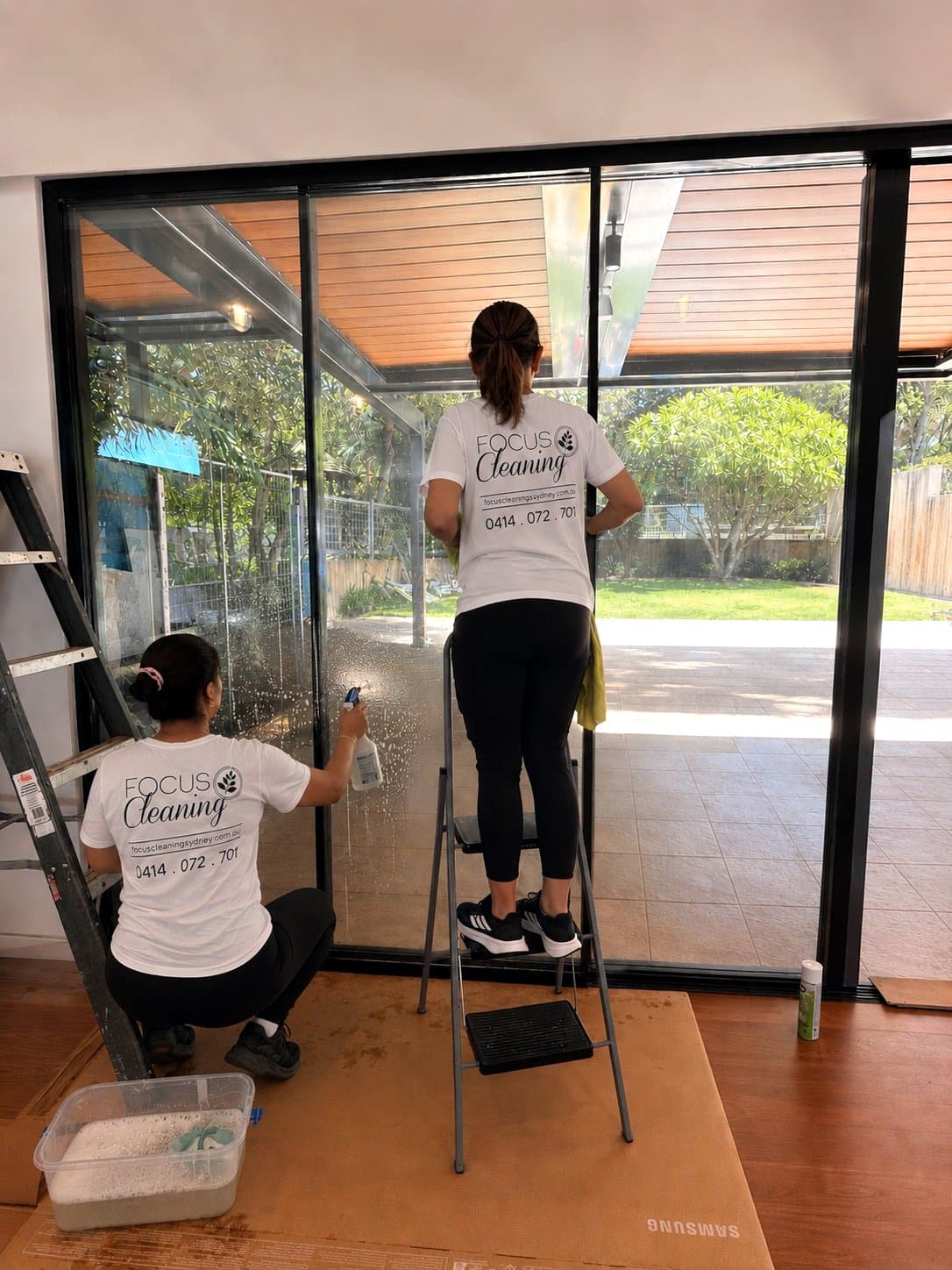 Focus team cleaning glass doors on site