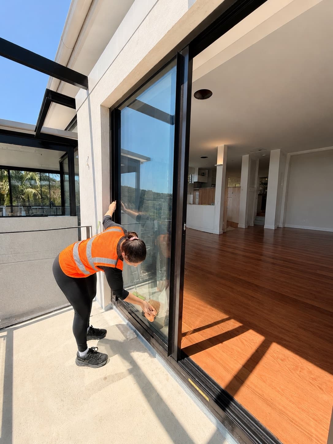 Focus cleaner in hi-vis finishing glass doors on a new-build handover