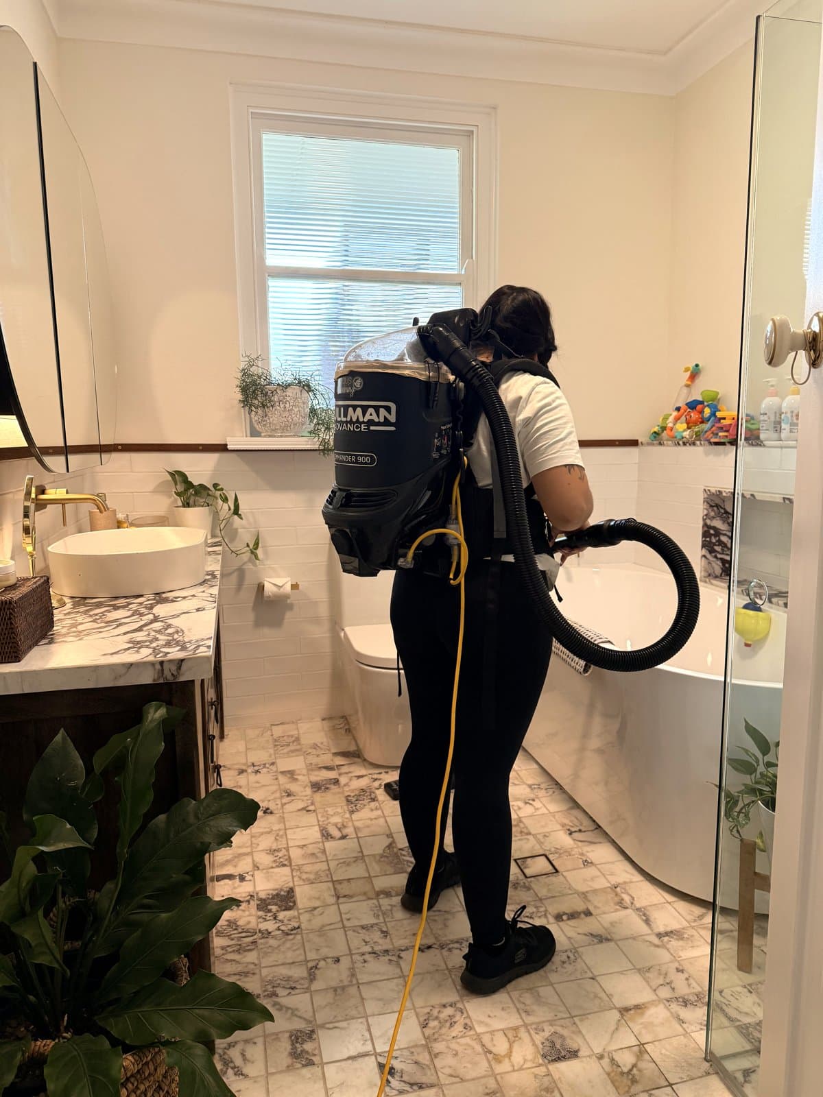 Focus cleaner vacuuming a Sydney bathroom