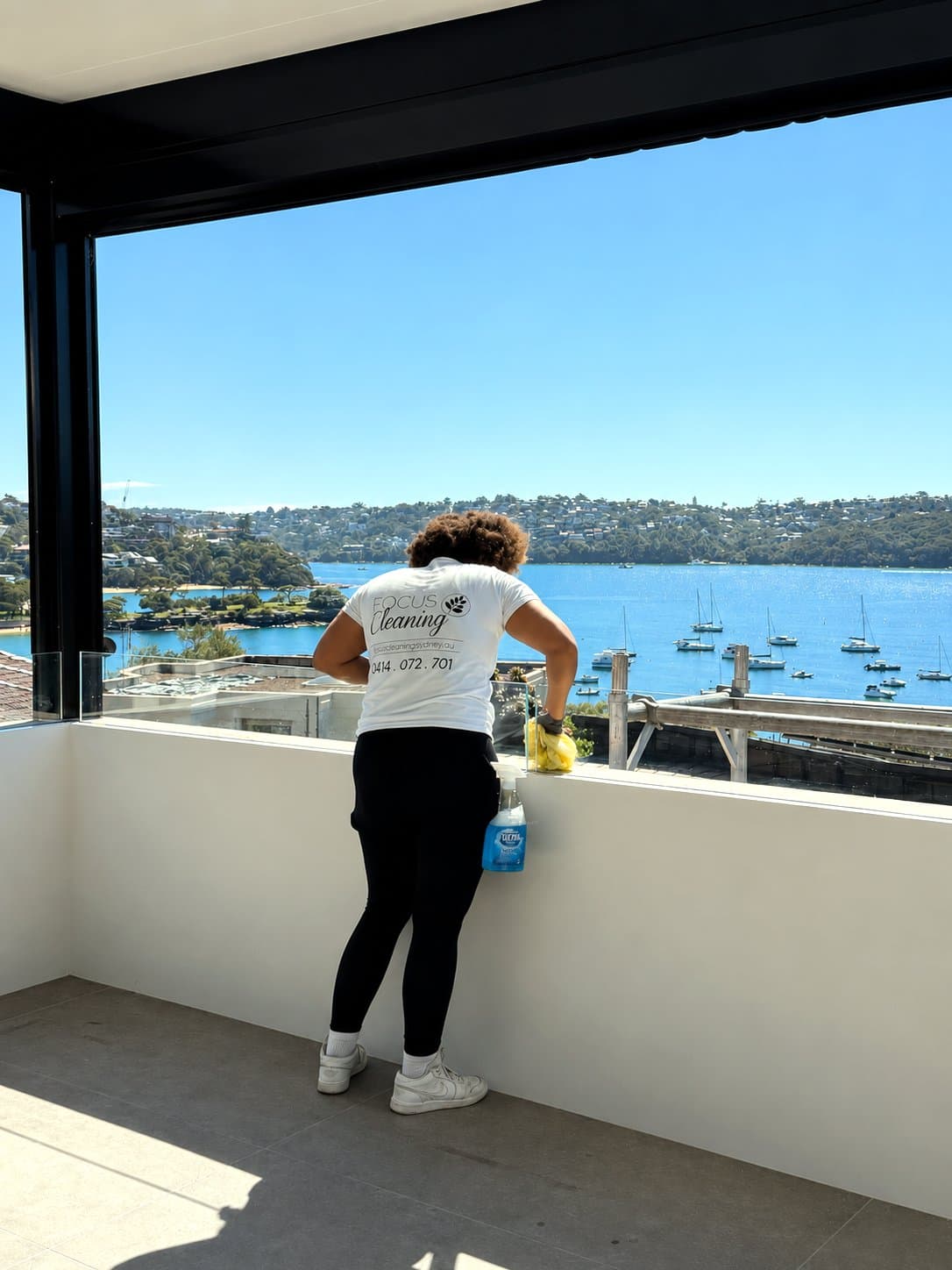 Focus cleaner finishing a balcony with harbour views
